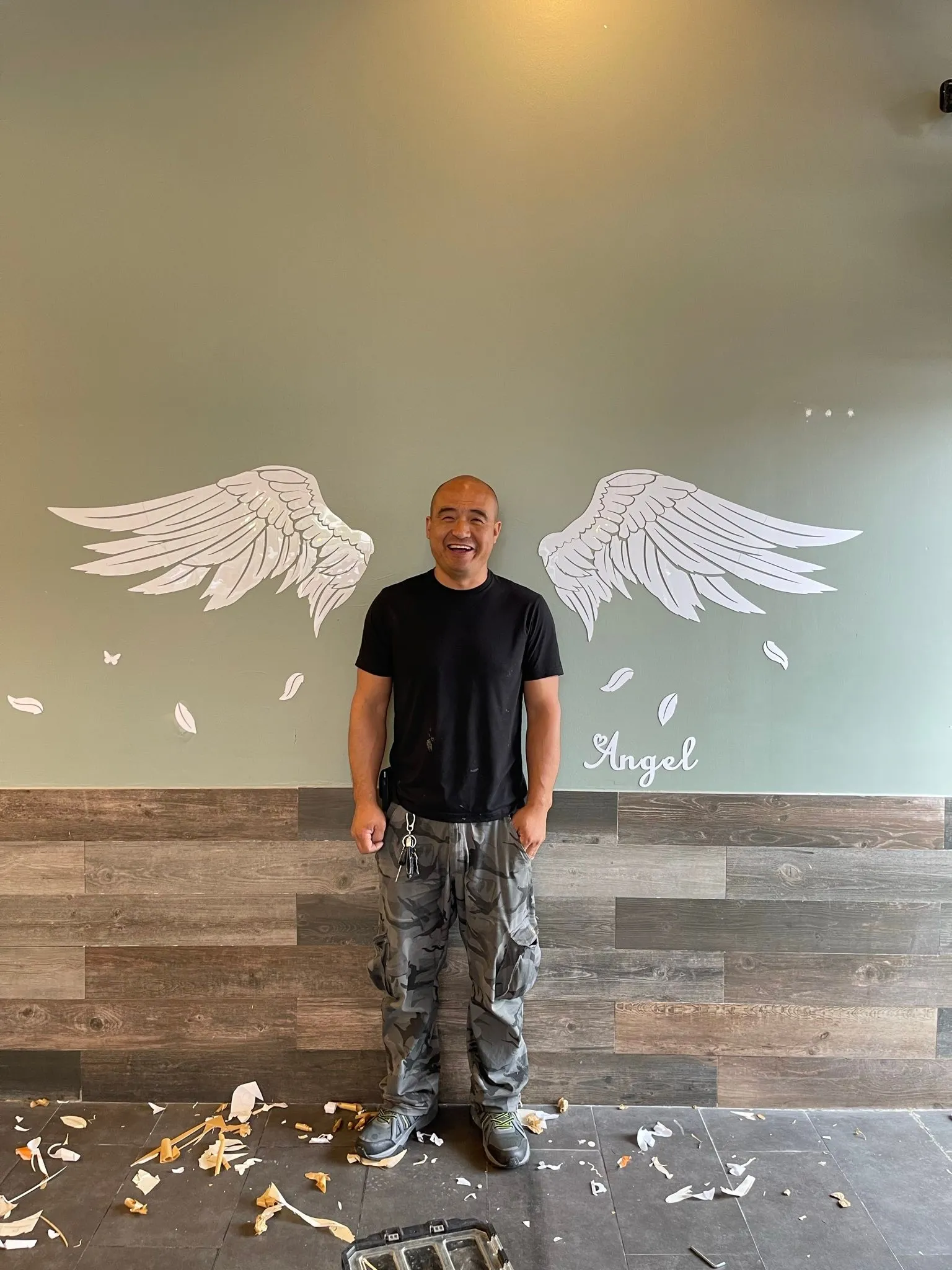 Asian man smiling near angel wings